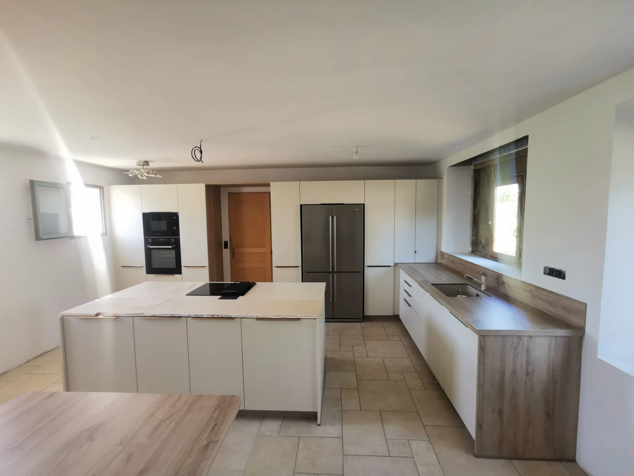 Gros plan sur un îlot de cuisine moderne avec évier intégré et robinetterie design.